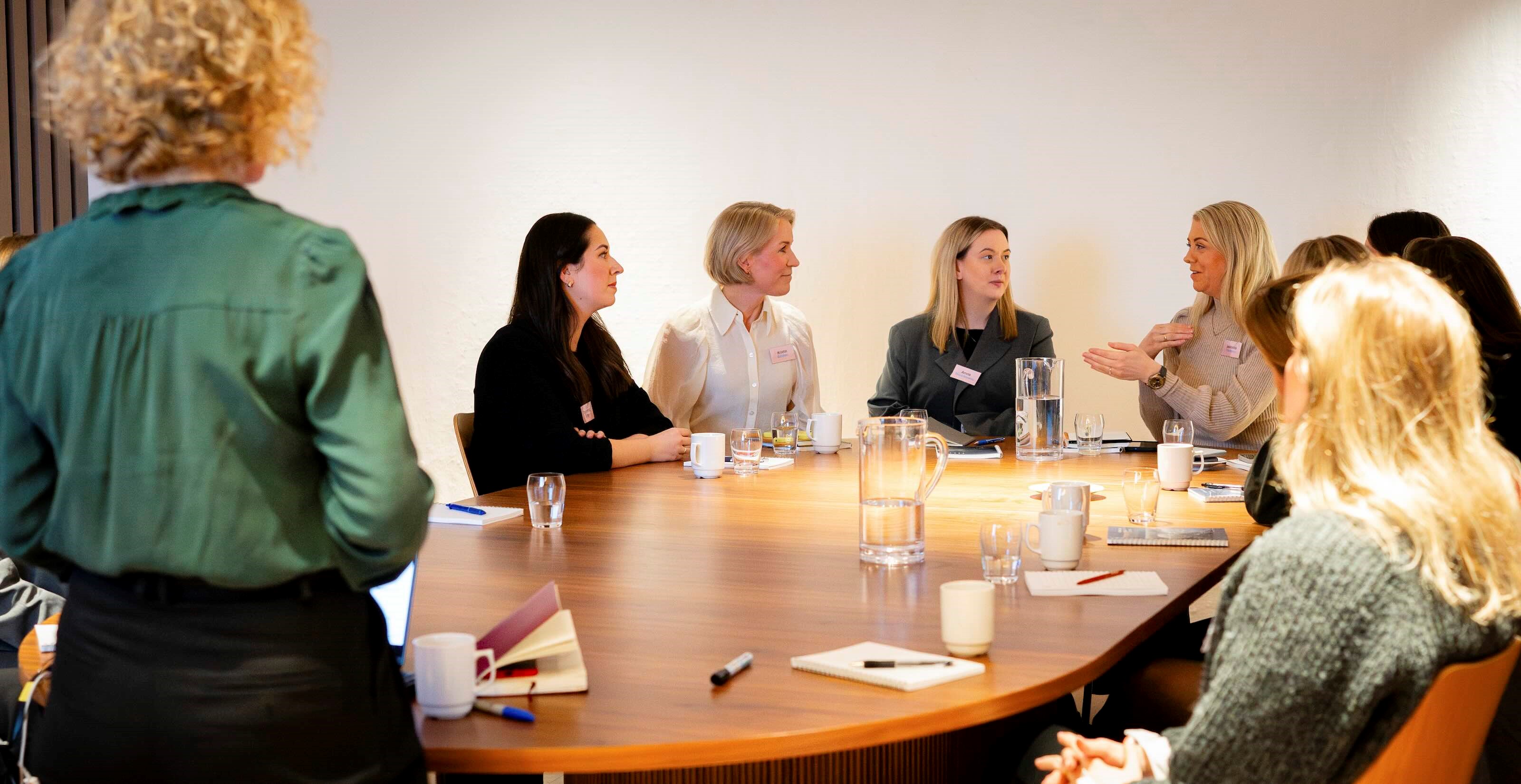 Kvinner diskuterer rundt et møtebord
