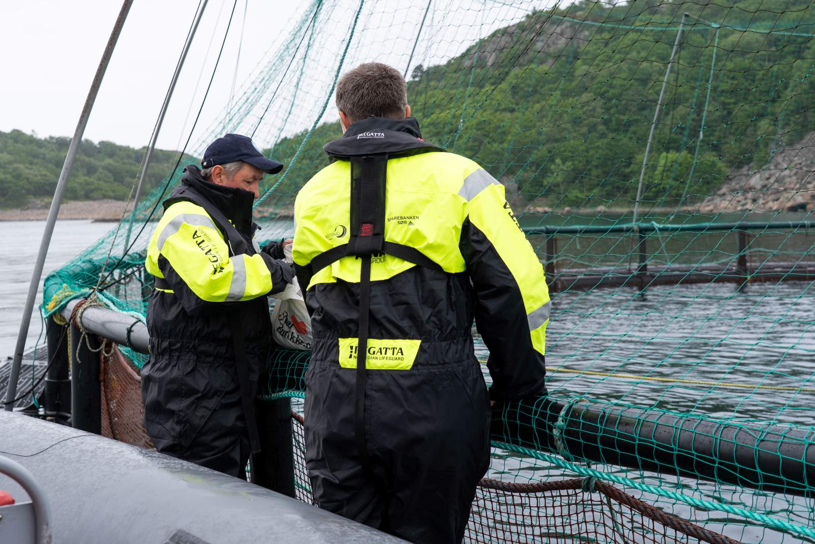 Eier av Korshavn havbruk AS, Åge Igland, viser Sør-fondets Trond Skjæveland en av merdene til firmaet.  