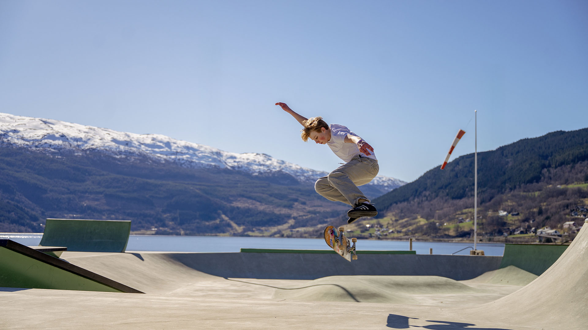 Gutt på skaterampe med nydelig norsk natur i bakgrunnen
