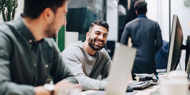 Mann med lue foran en fjellknaus