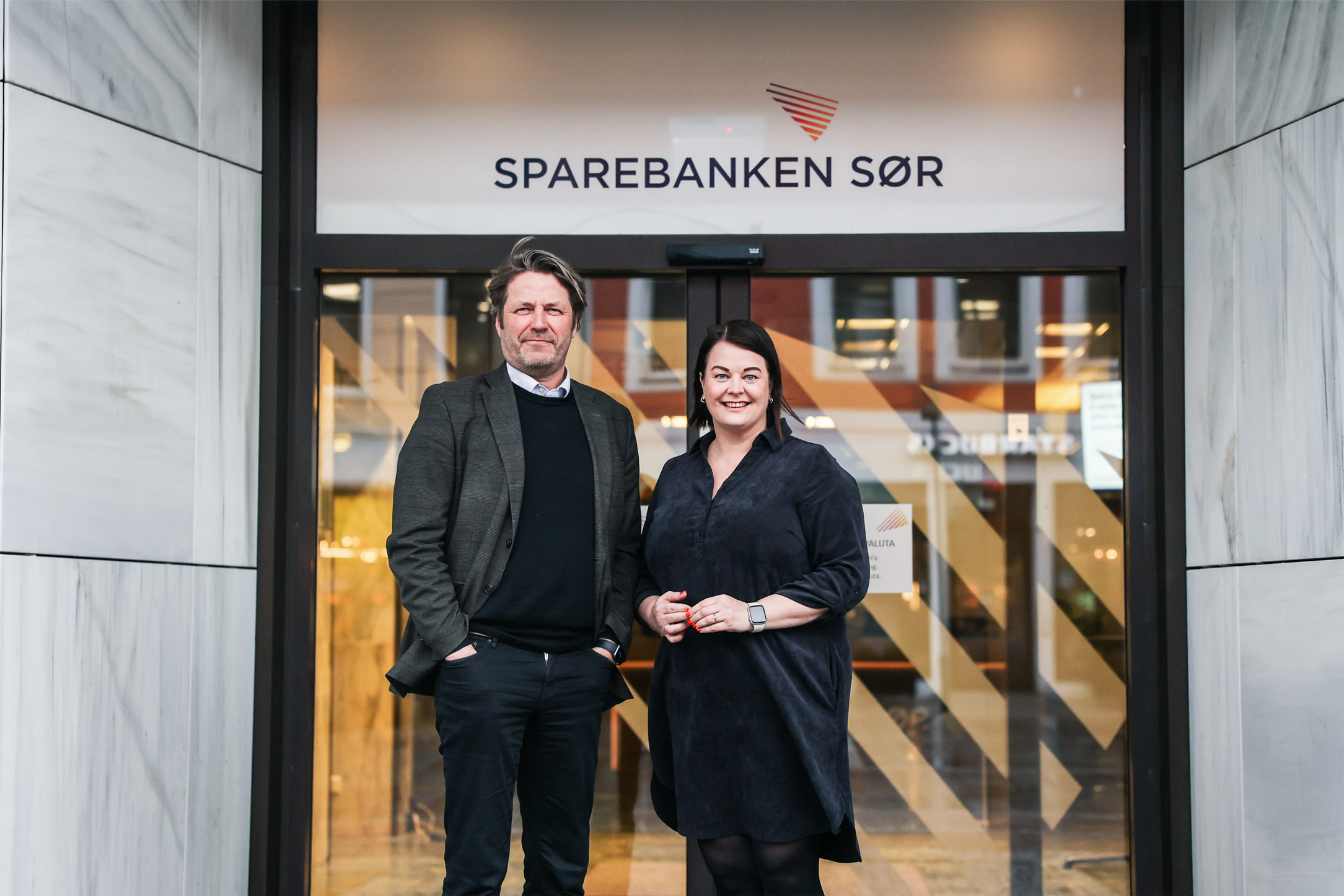 Eva Kvelland og Gunnar Thomassen foran inngangen til Sparebanken Sør