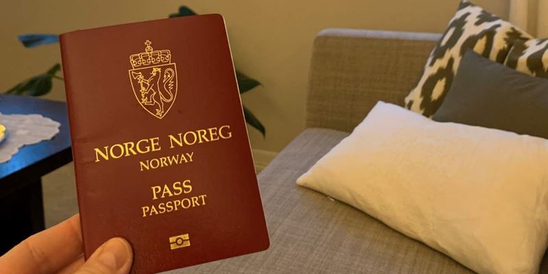 Hånd som holder et pass i stue