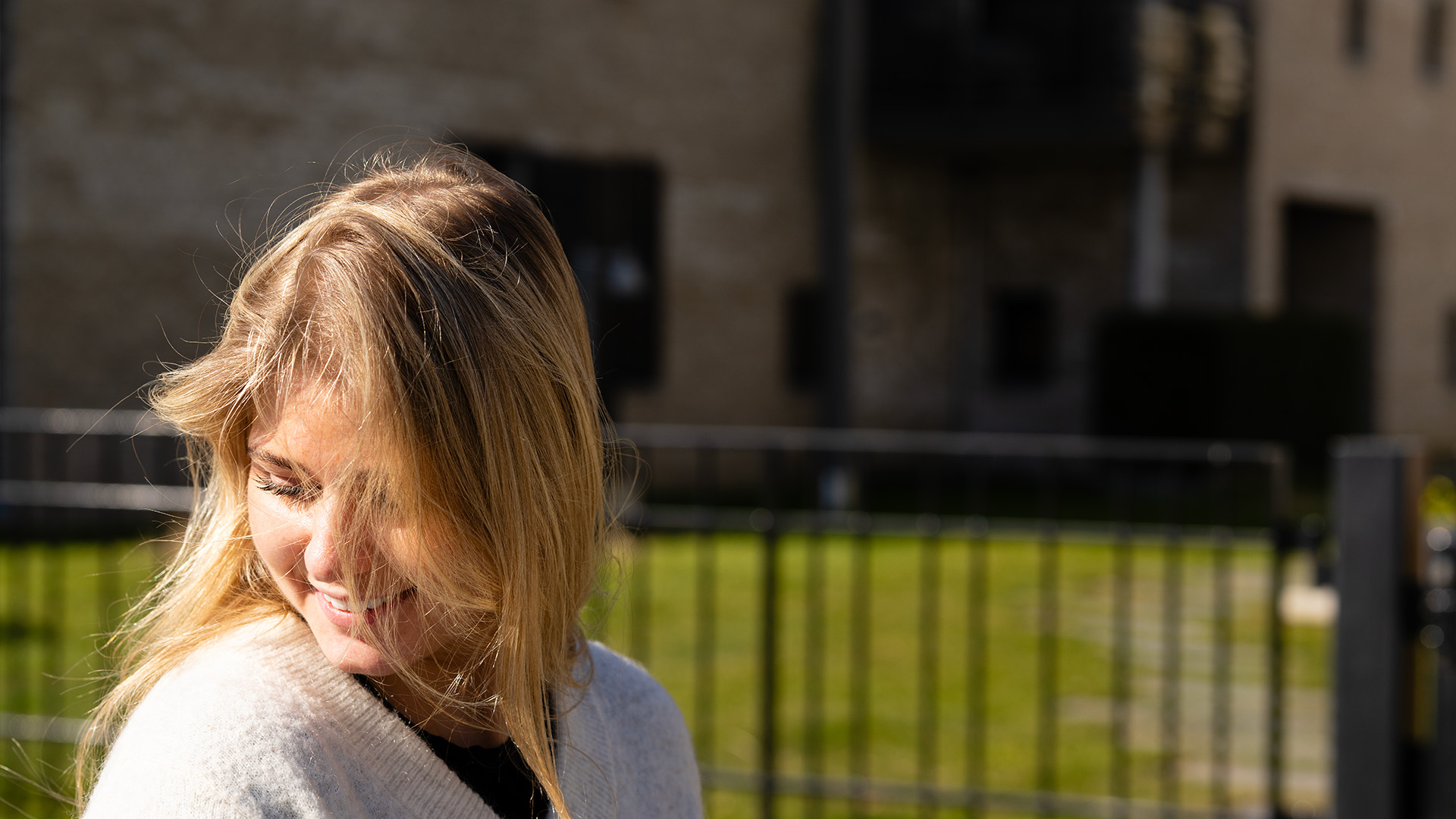 Kvinne ser ned og til venstre med ansikt mot kamera
