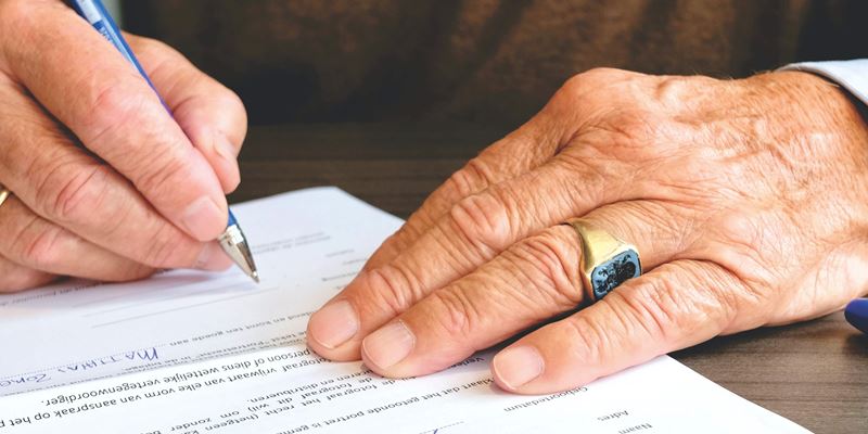 Hånd som holder en penn og signerer