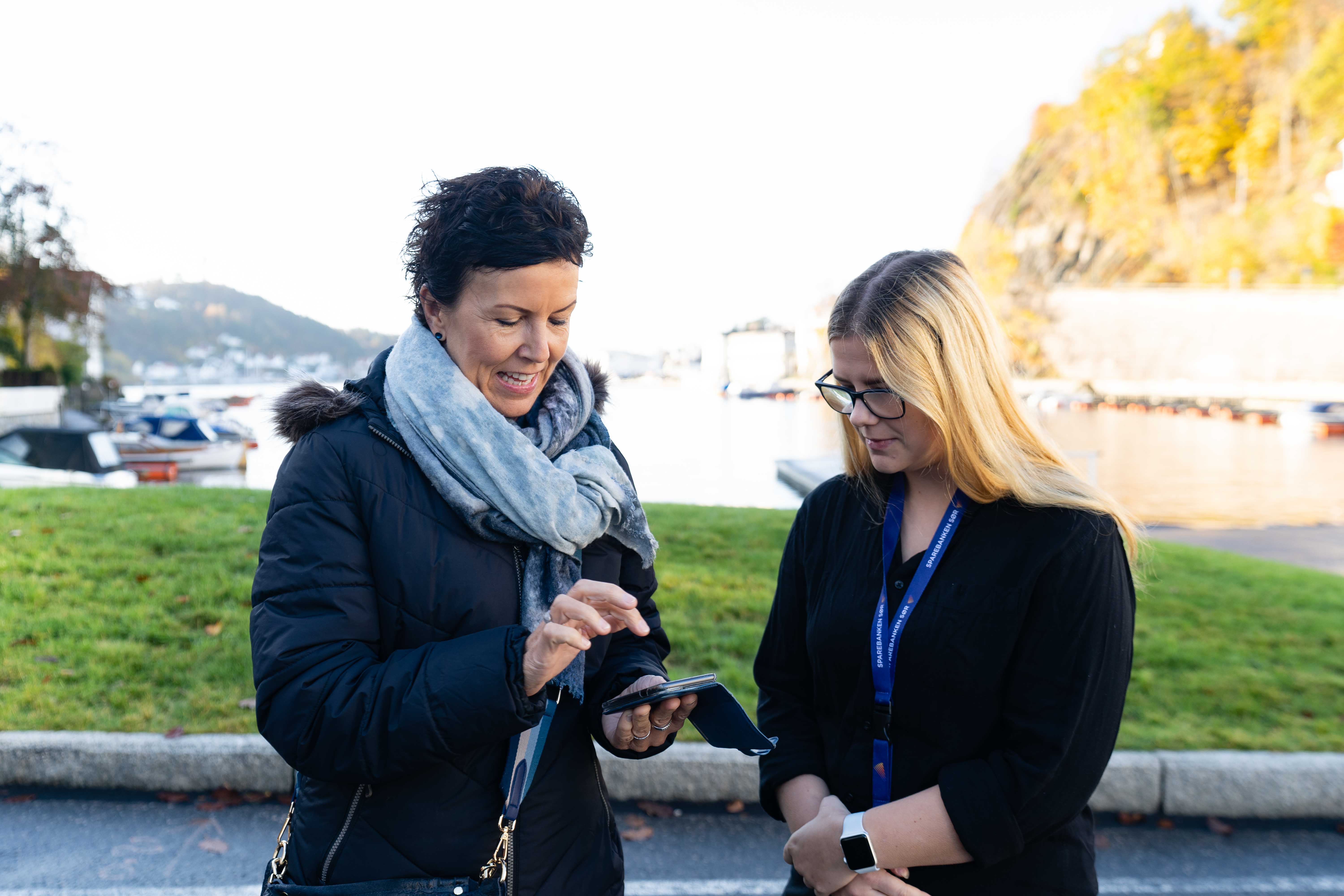 Lisbeth Ramsdal og Maylinn Kristiansen ser på mobilen