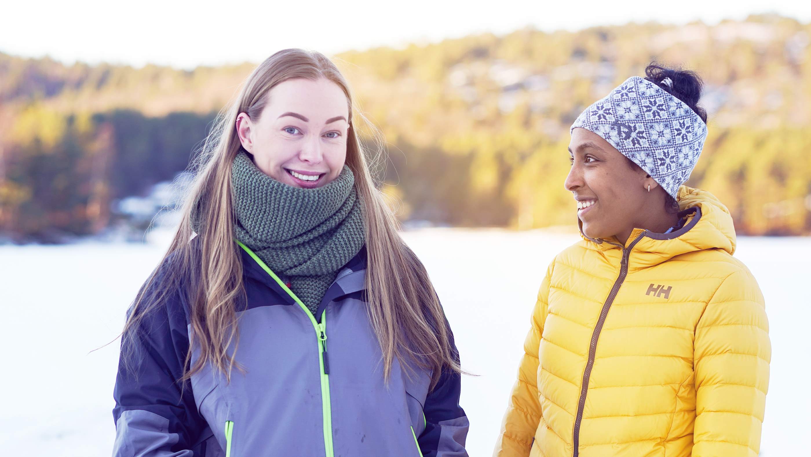 Two women talking and walking in the woods at winter time