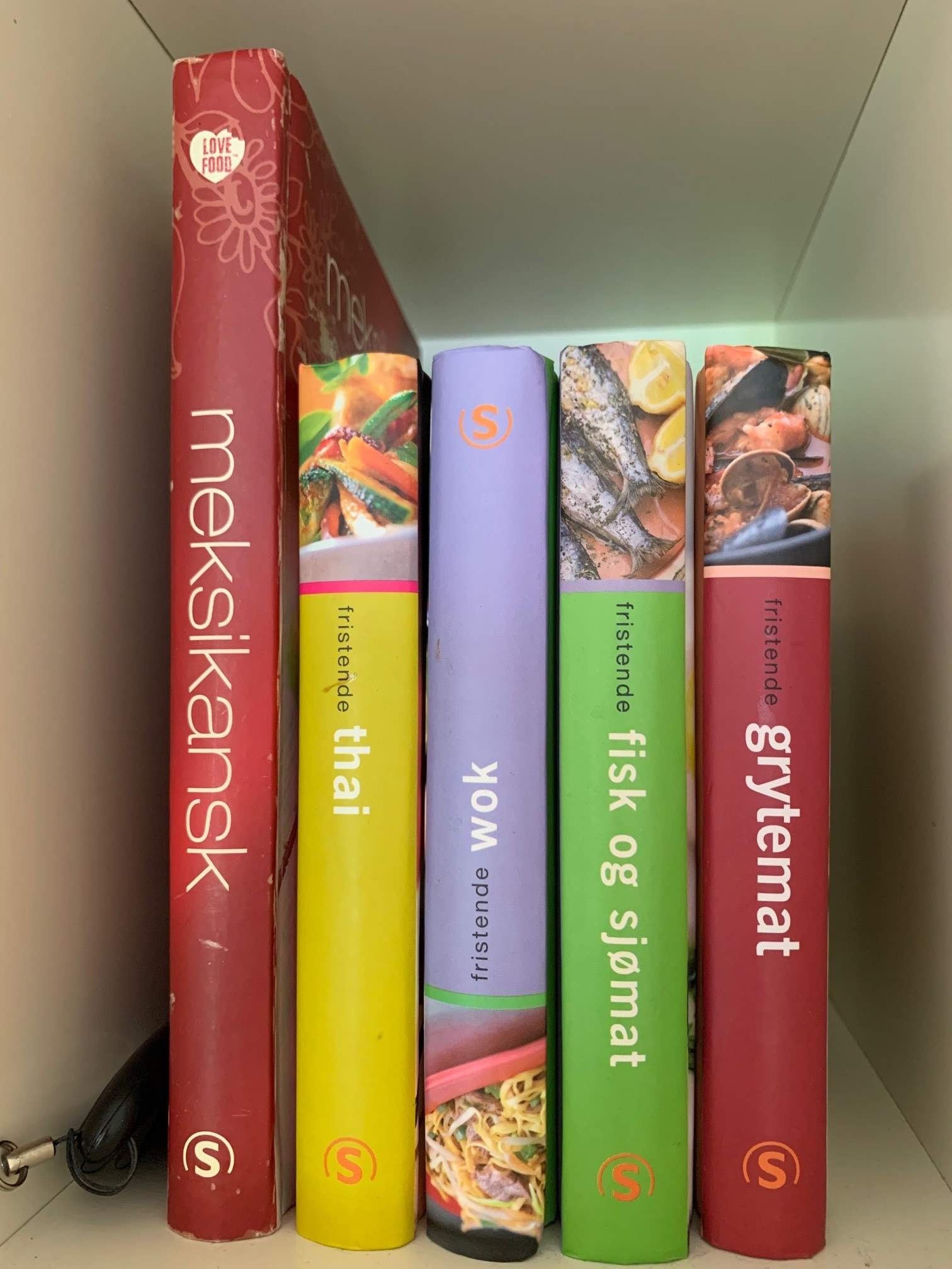 Foto av bøker i bokhylle med kodebrikken gjemt på siden